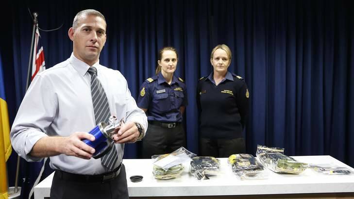 ACT Policing drug and organised crime team detective sergeant Shane Scott shows how drugs were concealed in a mug. Photo: Jeffrey Chan