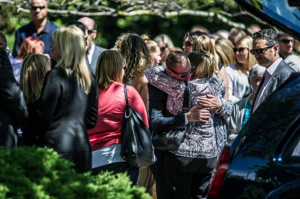David Turner, partner of Kate Goodchild being comforted outside the funeral of siblings Kate Goodchild and Luke Dorsett. Photo: Karleen Minney