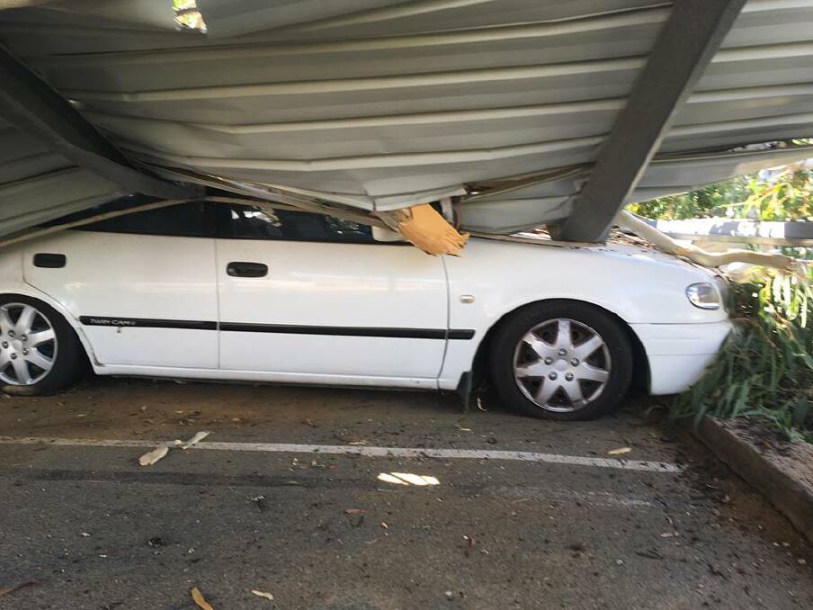 A car lays crushed underneath a gum tree, which fell in the Canberra suburb of Watson on Thursday. Photo: Edward Doherty