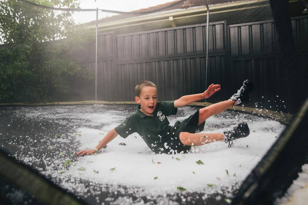 Campbell Ashcroft, 6, of Yarralumla, playing in the hail on his backyard trampoline. Photo: Rohan Thomson