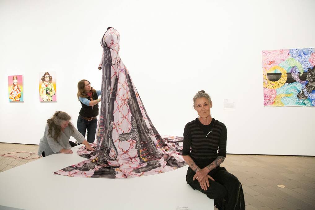 Artist eX de Medici (right) in front of her work 'Shotgun wedding dress' which is now on display at the National Gallery of Australia. Photo: National Gallery of Australia