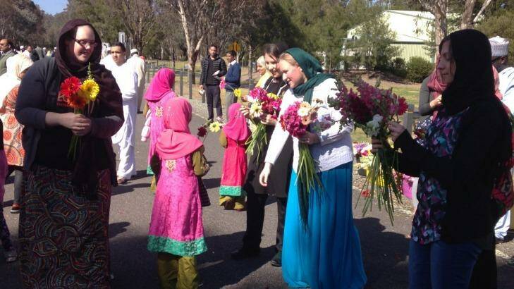 Floral gesture: Ten Canberran women hand out flowers to the ACT Islamic community in Bruce on Saturday Photo: Annabelle Lee