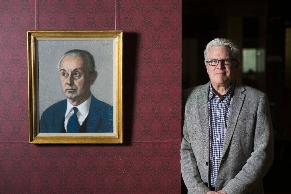 Curator Nat Williams with a portrait of Sir Rex Nan Kivell in a show of Kivell's collection at the National Library of Australia. Photo: Rohan Thomson