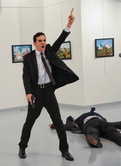 Turkish police officer Mevlut Mert Altintas gestures while shouting as the body of Russian Ambassador to Turkey, Andrei Karlov, lies at his side. Photo: Burhan Ozbilici/AP