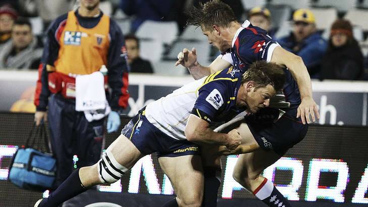 Making it count: Clyde Rathbone crunches Rebel Jason Woodward on Friday night. Photo: Getty Images