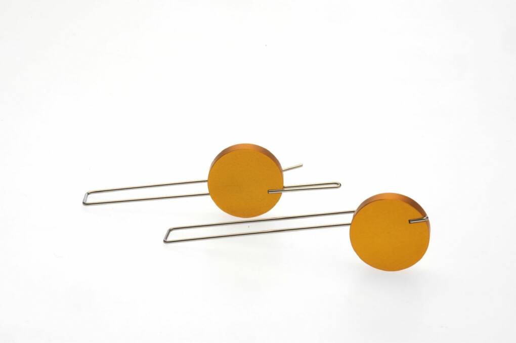 Off-centre earrings by Phoebe Porter made from yellow aluminium and stainless steel. Photo: Supplied