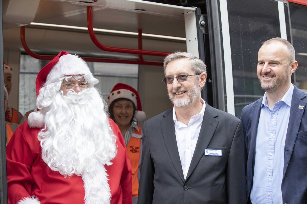 Santa, , St Vincent de Paul Society ACT president Warwick Fulton, and ACT Chief Minister Andrew Barr next to the tram in Gungahlin. Photo: Sitthixay Ditthavong