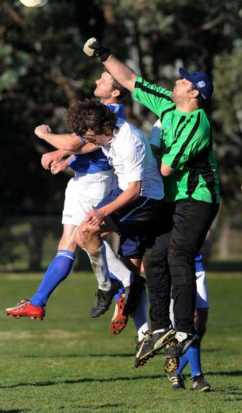Canberra Olympic goalkeeper Chris Bellgard   punches the ball away against Canberra FC. Photo: Richard Briggs