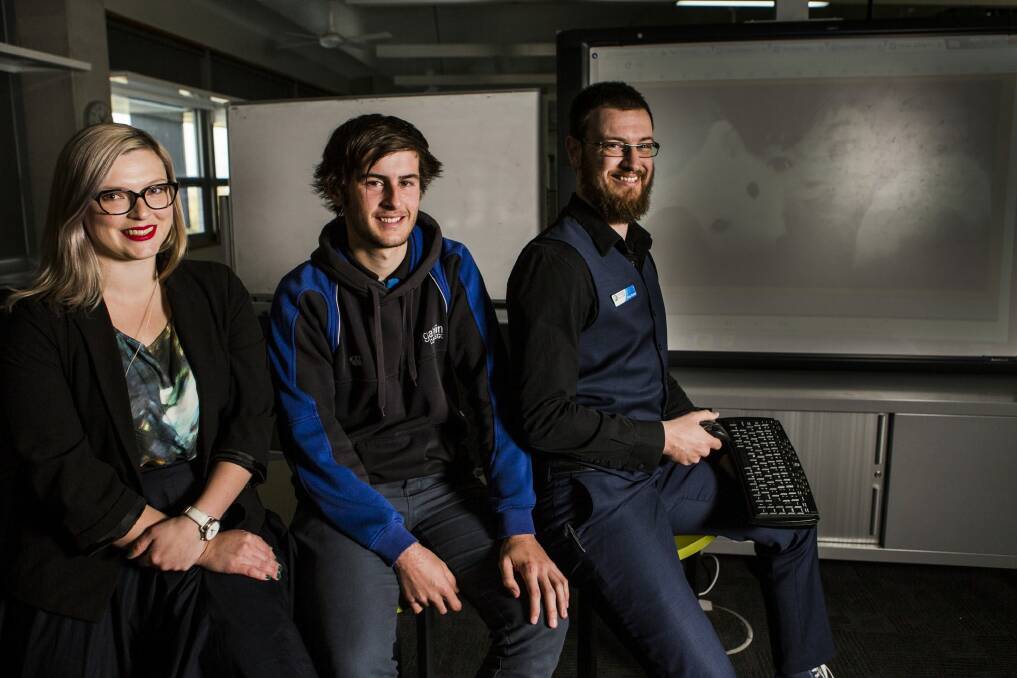 Gungahlin College has included computer games as part of its English syllabus. The unit's architects, English teachers Lisa Batum and Mark Clutton, sit either side of year 12 student Adam Donald. Photo: Jamila Toderas