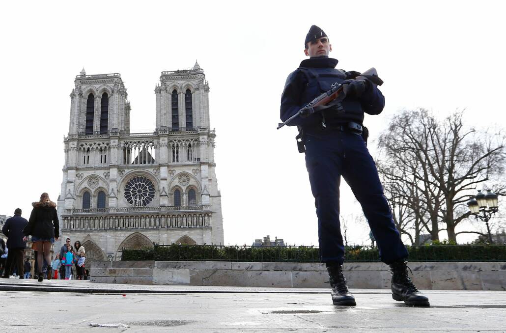 A French police officer stands guard outside Notre Dame cathedral in Paris earlier this year. Photo: AP