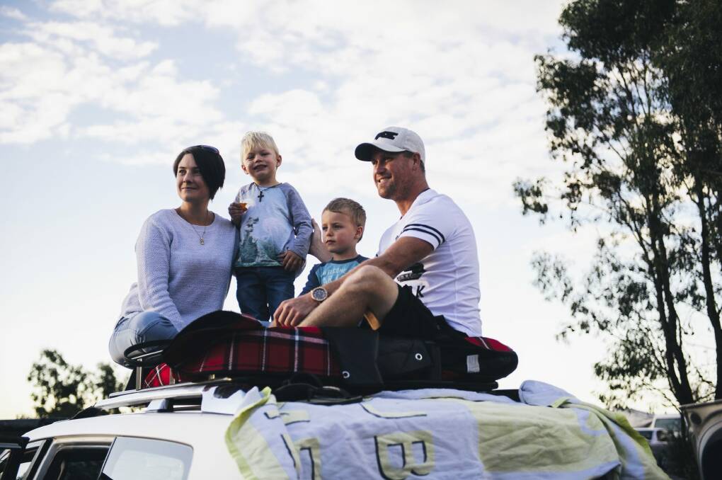 Dustrin and Kirstie Stephen with sons Jarrod, 5, and Tyler, 3, perch on top of their four-wheel drive to get a better view at Mount Ainslie. Photo: Rohan Thomson