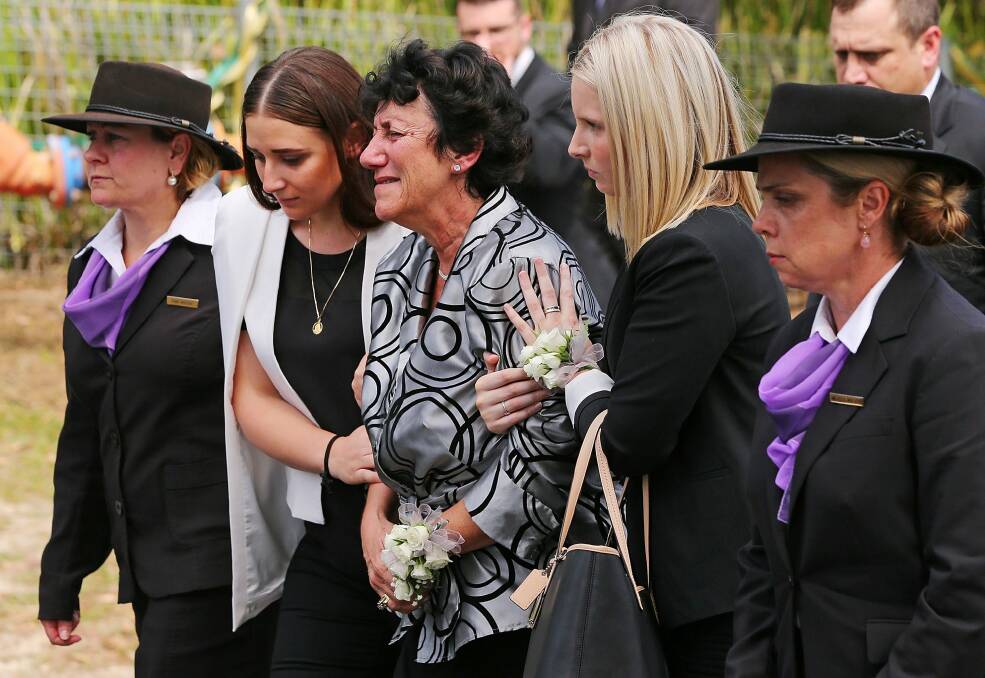 Phillip Hughes' mother, Virginia Hughes, centre, with daughter Megan Hughes, left, at the funeral. Photo: Michael Dodge