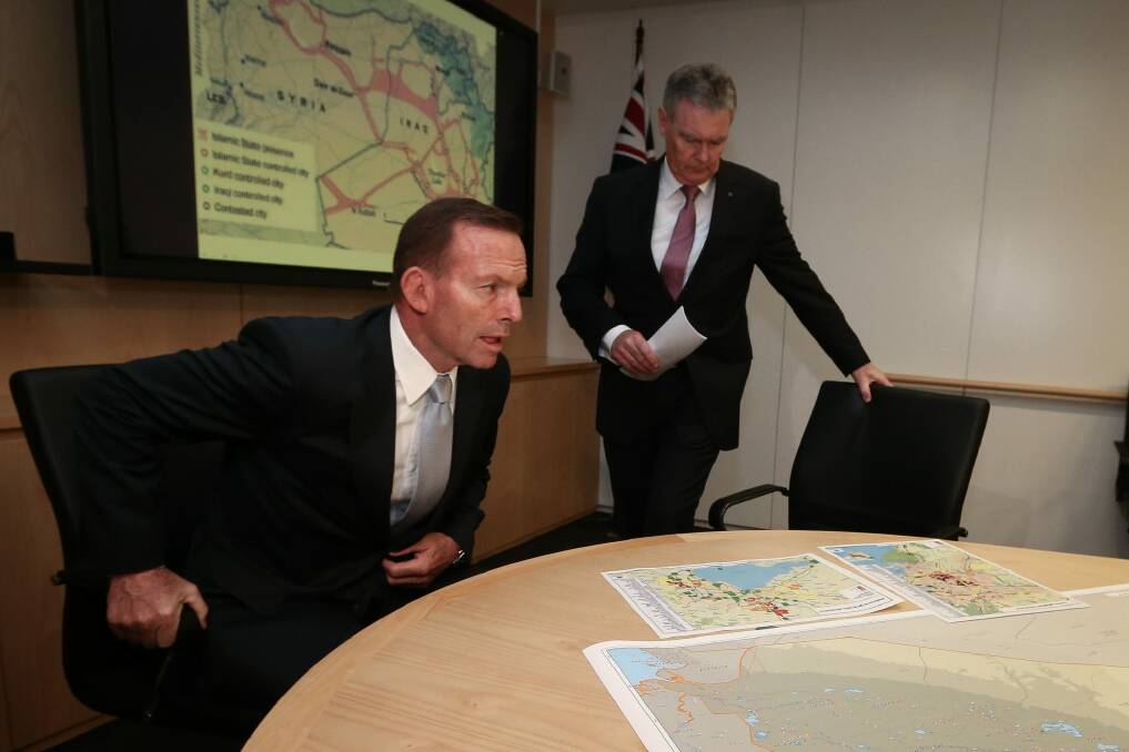 Then prime minister Tony Abbott is briefed by ASIO director-general Duncan Lewis on Islamic State in June.  Photo: Alex Ellinghausen