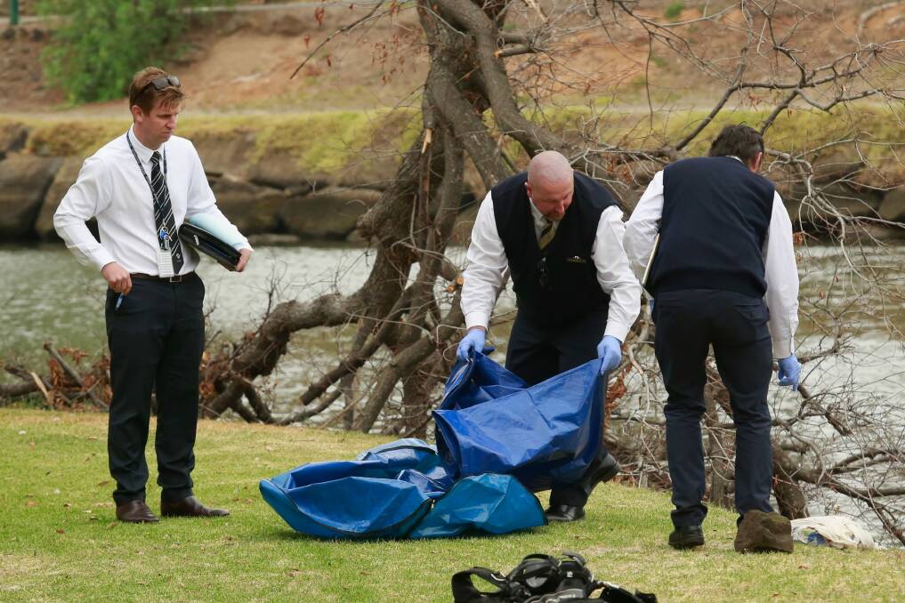 Police investigating the death of Brendan Bernard take away evidence from the banks of the Maribyrnong River.  Photo: Chris Hopkins