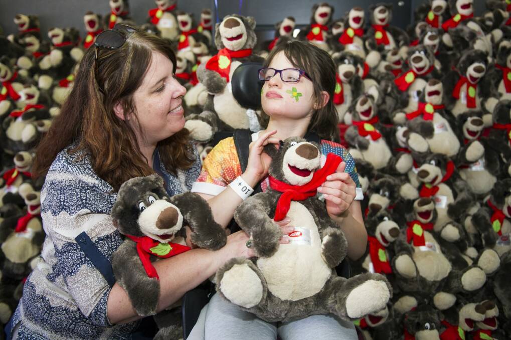 Melissa Keith and Lily (10) with some of the teddy bears being given out to children at the Canberra Special Children's Christmas Party at Thoroughbred Park on Sunday.
 Photo: Rohan Thomson