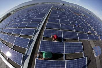 Workers install solar panels on the roof of the Palexpo Exhibition Center in Geneva. Photo: Reuters