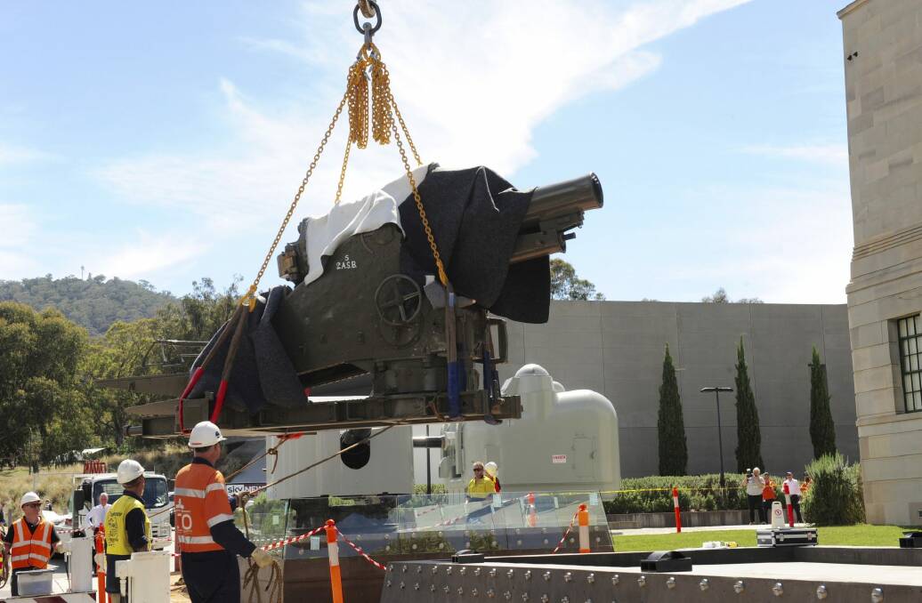 A WWI howitzer,
weighing 7.5 tonnes, being lowered into place in the grounds of the Australian War Memorial.  Photo: Graham TIdy