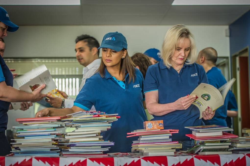 Volunteers sort childrens books at the launch of The Smith Family's 2016 Christmas Appeal. Photo: Karleen Minney