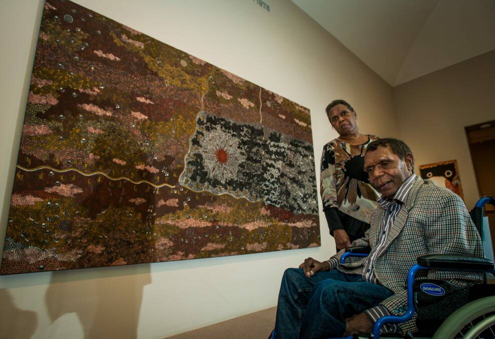 Artist Clifford Possum Tjapaltjarra's children Gabriella, from Melbourne, and Lionel Possum, from Alice Springs, see their father's work "Warlugulong" at the National Gallery of Australia. Photo: Elesa Kurtz