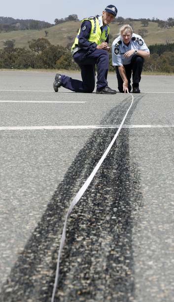 Sergeant Dick Dauth and Senior Constable Jane MacKenzie from Collision Investigation and Reconstruction Team measuring skid marks during training at the Australian Federal Police Training Facility. Photo: Jeffrey Chan