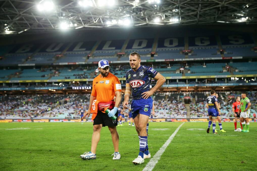 Sidelined: Josh Reynolds leaves the field just before half-time against the Raiders. Photo: Getty Images