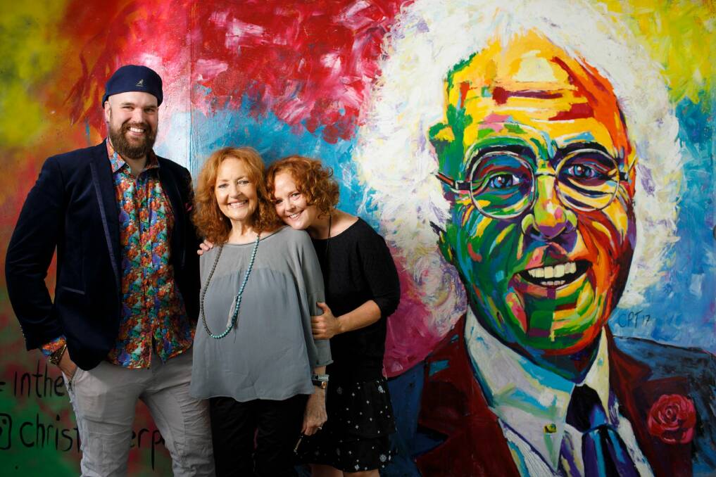 Artist Christopher Paul Toth stands with Diana and Melanie Hanna in front of a mural he painted to honour the memory of Canberra businessman John Hanna.  Photo: Sitthixay Ditthavong