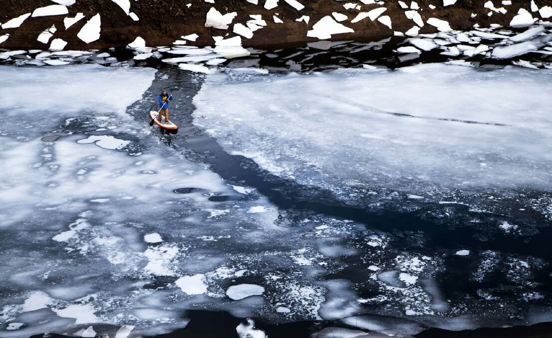 Jake Sims' spectacular photo of his friend paddle-boarding on an icy alpine lake. Photo: Jake Sims