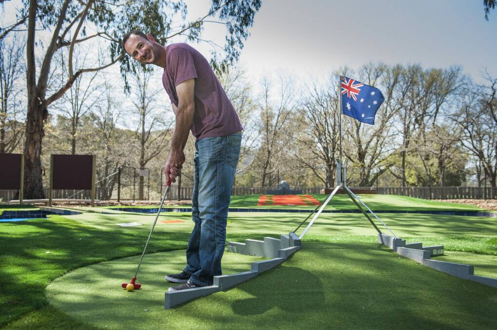 Owner of Yarralumla Play Station Jason Perkins teeing off at the Canberra-themed mini golf course. Photo: Elesa Kurtz