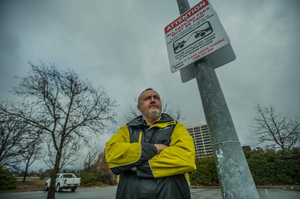 Wilson Parking enforcement officer Graham Bell and the signs installed to encourage people to pay for parking and parking fines. Photo: Karleen Minney