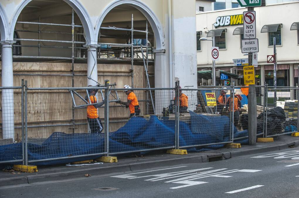 Workers remove scaffolding from the building at the corner of London Circuit and East Row Photo: Karleen Minney