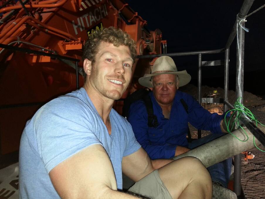 Rugby star David Pocock and farmer Rick Laird chained to a digger on Sunday, before they were arrested. Photo: Supplied