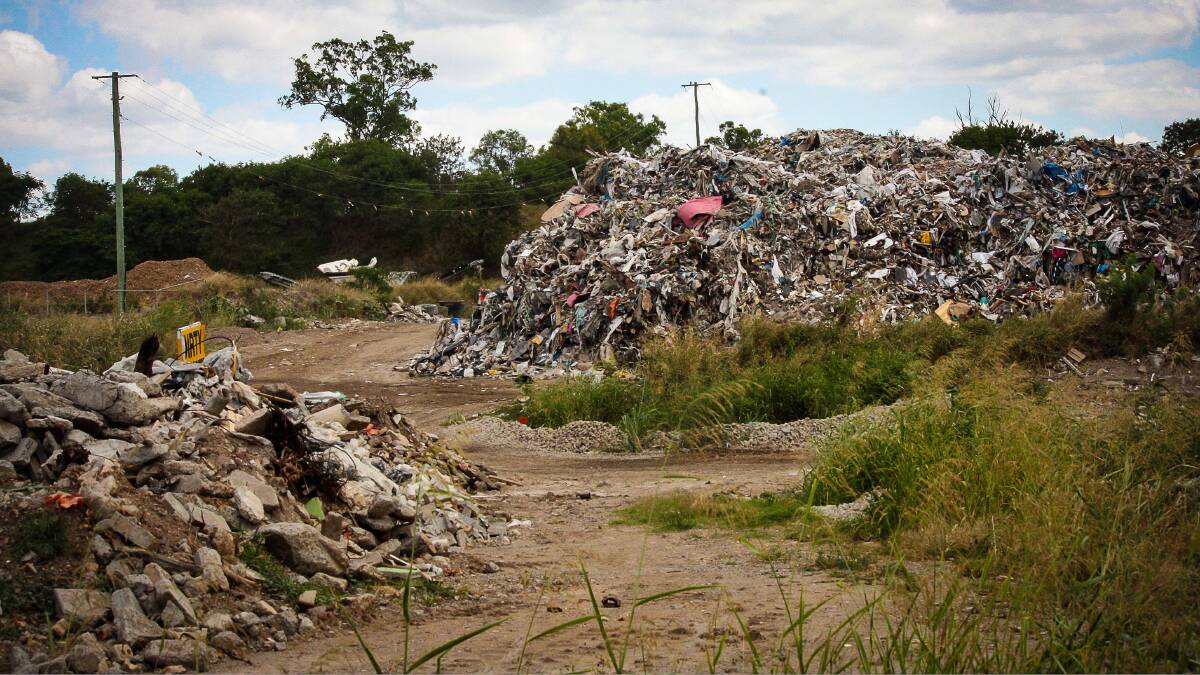 In the background: The white tip of the recycling machine is just visible between the mounds of waste at Cleanaway's Willawong recycling facility. Drivers frequenting the facility said it was rarely seen working. Photo: Mark Solomons