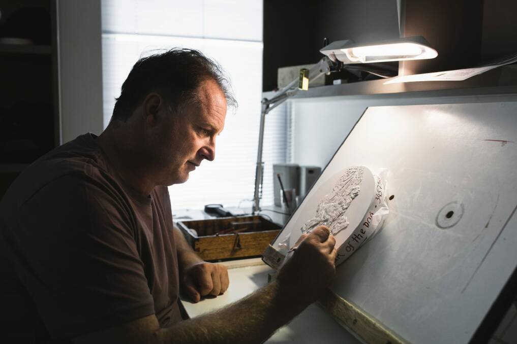 Royal Australian Mint sculptor and coin designer Stevan Stojanovic works on a final plaster positive for the mint's 2018 Year of the Dog collection.  Photo: Jamila Toderas