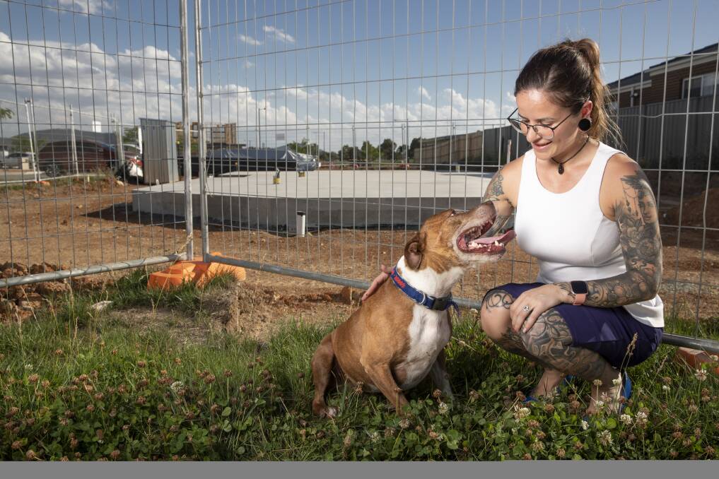 Sam Reichstein and her dog Goose play in front of a block of land that she recently bought in Throsby. Photo: Sitthixay Ditthavong