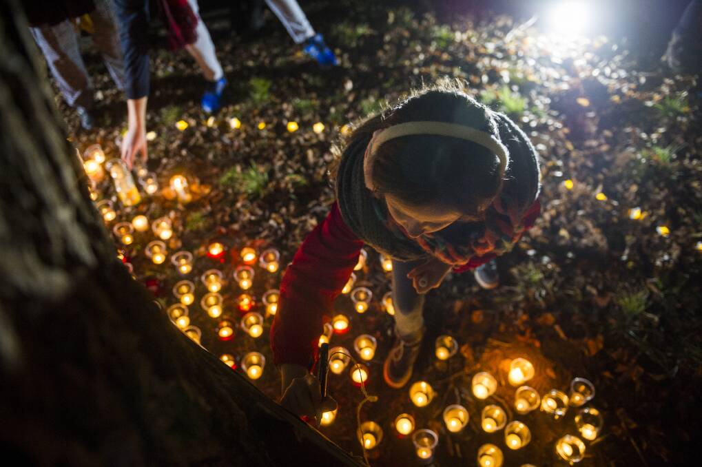 Molly Gifford, 11, writes a message at the vigil for Eurydice Dixon at Haig Park. Photo: Dion Georgopoulos
