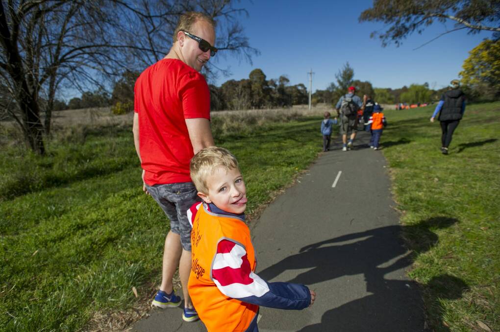 Stu and Ari Blackford, 5, with children from Junior School at the Charnwood campus of Brindabella Christian College
school which is re-introducing walking and riding bikes to school. Photo: Jay Cronan