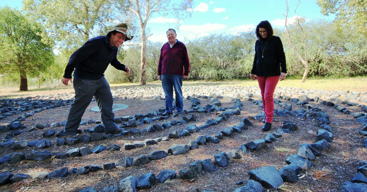 Tim the Yowie Man walking the St Clement's labyrinth with staff members Rev William Goldman and Sue Rolfe.  Photo: Dave Moore