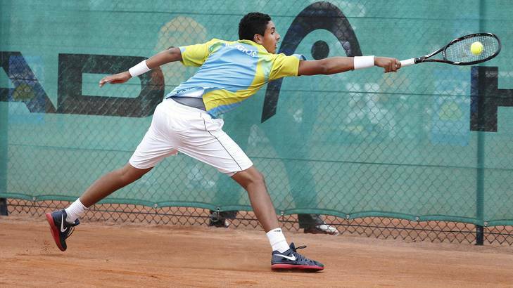 Canberra Velocity's Nick Kyrgios slides across the clay to reach a backhand. Photo: Jeffrey Chan