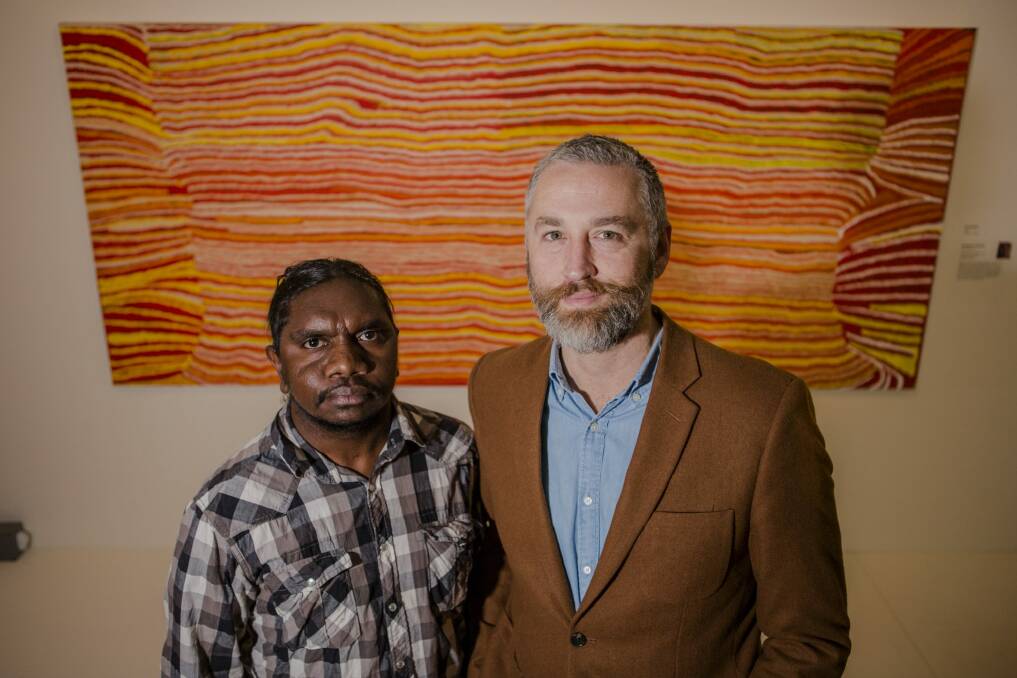 Indigenous artist/film maker Curtis Taylor and National Museum consultant curator Dr John Carty in front of the artwork Kaninjaku 2008, by Kumpaya Giraba, Martumili Artists, which was the inspiration for the exhibition title. Photo: Jamila Toderas