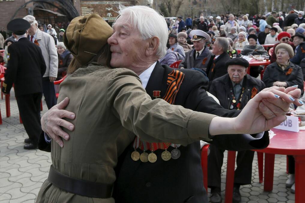 An elderly man and a girl dance at a Victory Day party in the Siberian city of Krasnoyarsk. Photo: Ilya Naymushin