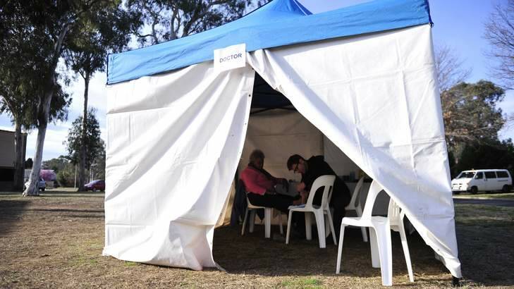 Dr Andrew Palfreman with patient Thelma Weston at Winnunga Nimmityjah Aboriginal Health Service in Narrabundah, in a tent they say is needed to overcome a critical shortage of space at the facility. Photo: Jay Cronan