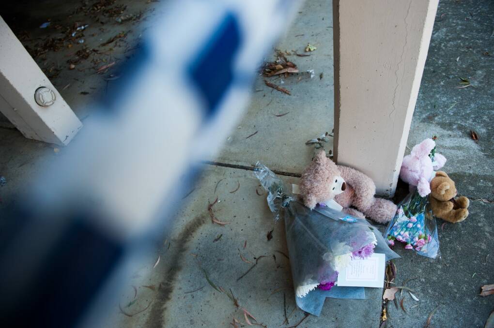 Floral tributes lay outside a unit tower in Queanbeyan where a baby girl died in a fire on Monday. Photo: Elesa Kurtz