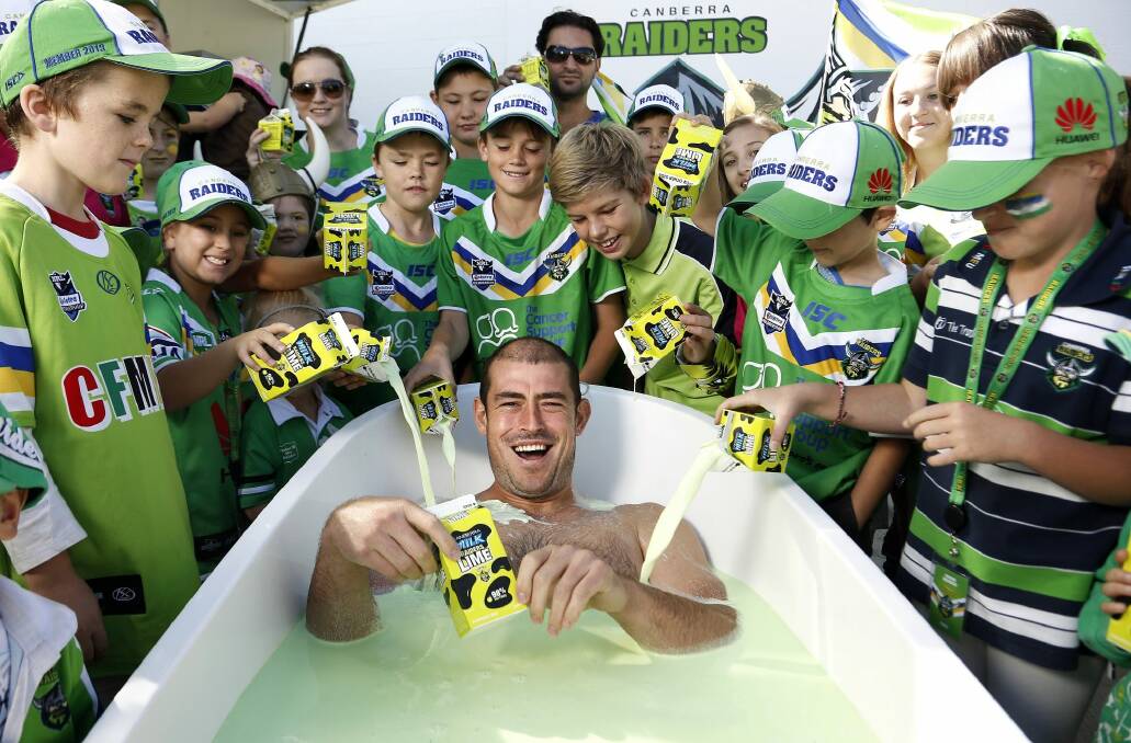 Former Raiders captain Terry Campese takes a bath in Raiders Lime when the milk was reintroduced in 2013. Canberra Milk has stopped production. Photo: Jeffrey Chan