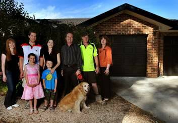 Lara and the Davidson family, in front of their rebuilt house last January. Photo: Gary Schafer