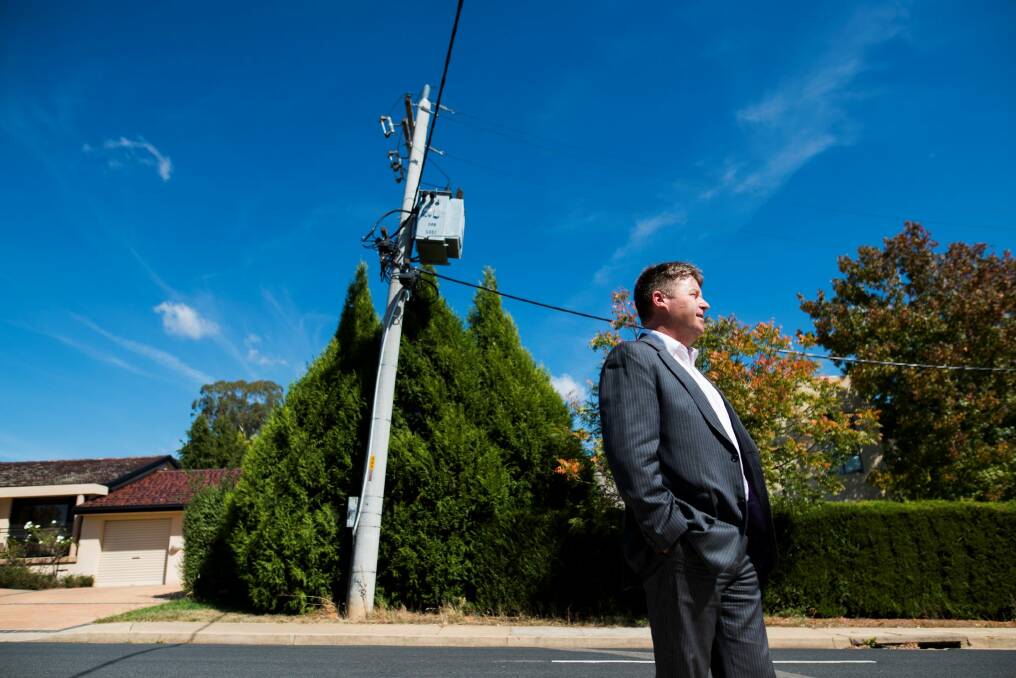 Jonathan Mandl on Hicks Street in Red Hill with a power pole he is concerned could fall over. Photo: Rohan Thomson