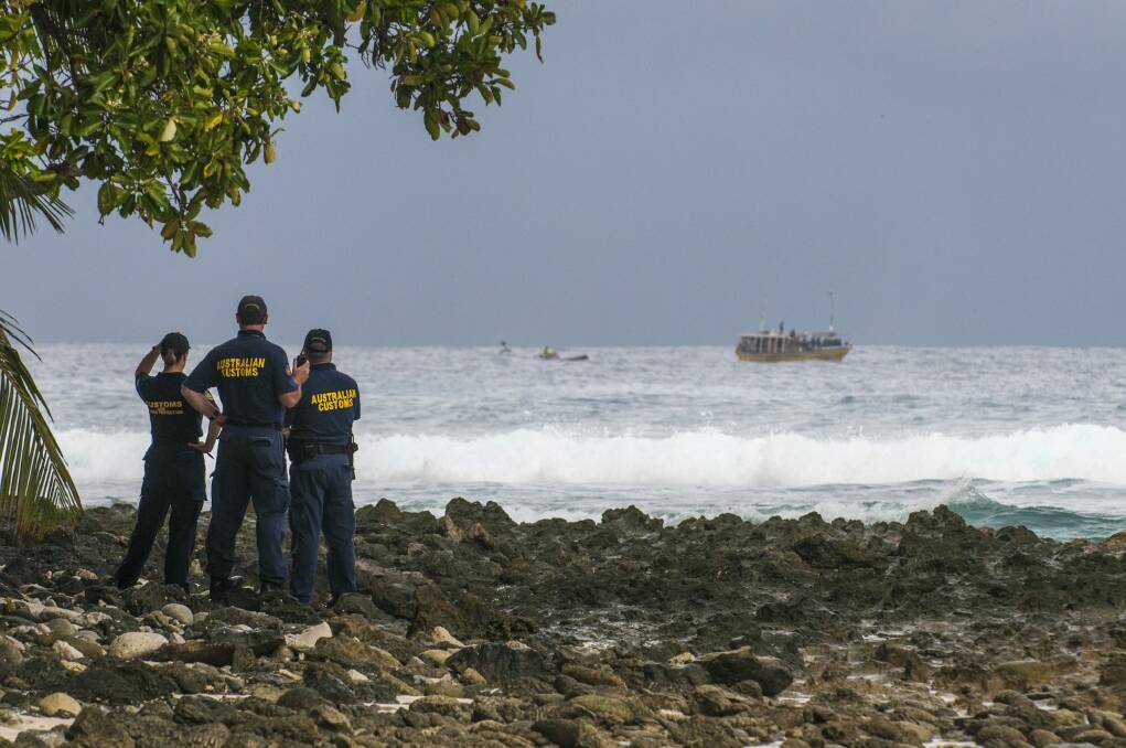 Customs officials watch a boat filled with asylum seekers approach the Cocos Islands in 2012. Photo: Karen Willshaw