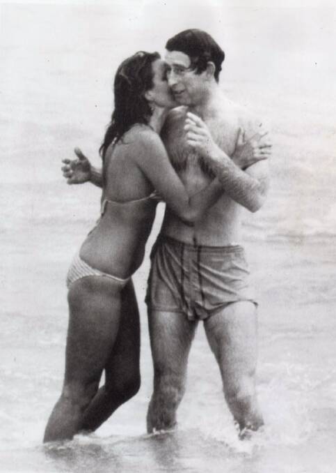 Prince Charles is kissed by Perth model Jane Priest while surfing at Cottesloe.