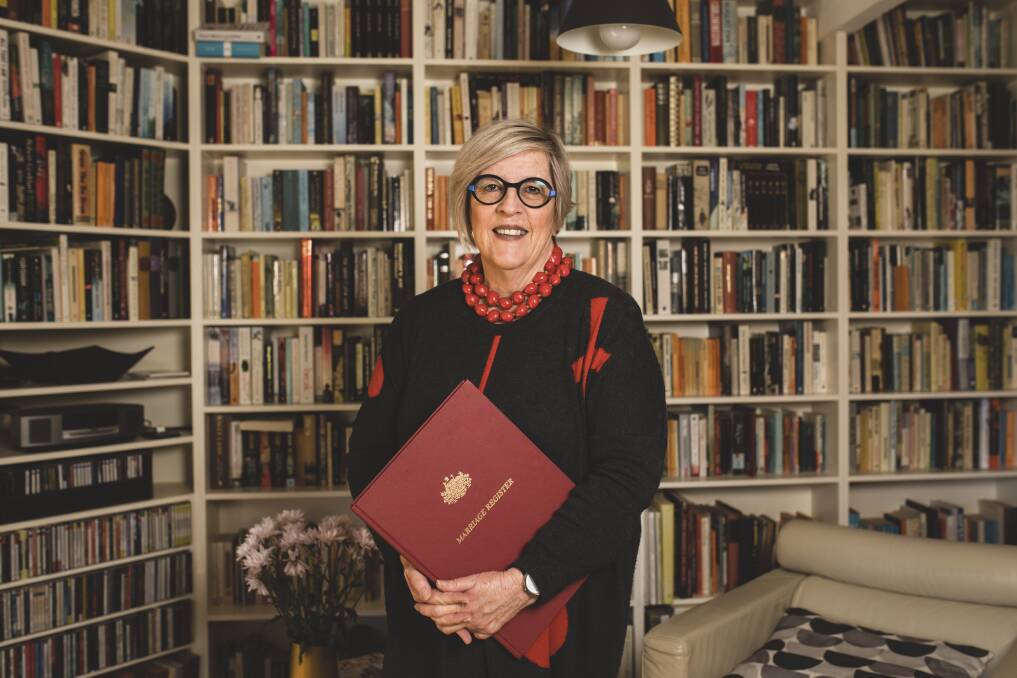 Marriage celebrant Judy Aulich, in front of the bookshelves in her living room where she often marries her clients. Photo: Jamila Toderas