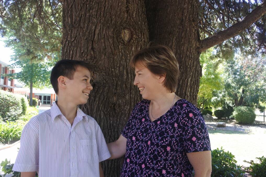 Daramalan College student Dylan Joe, 13, with his mum Jill Pareezer. Dylan, who cares for his mum who has disabilities, has been chosen to turn on the lights at Enlighten. Photo: Megan Doherty