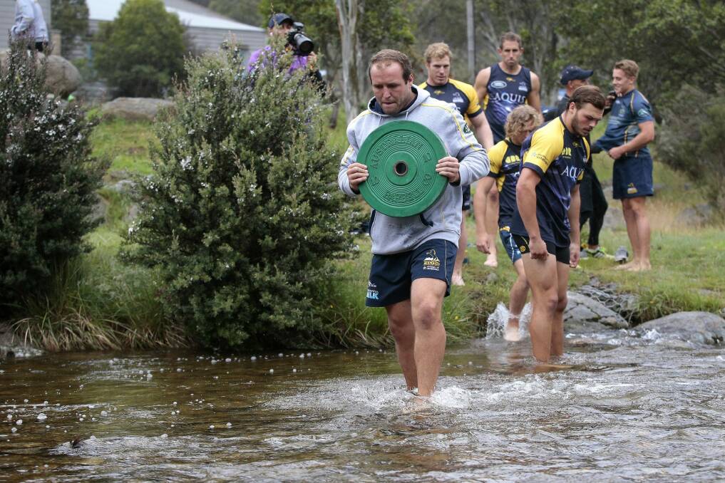 Players had to carry weights across a creek as part of the challenges. Photo: Jeffrey Chan